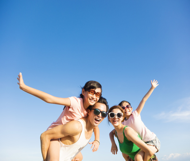 щаслива сім'я розважається на відкритому повітрі на фоні блакитного неба
 - Фото, зображення