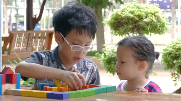 Kinder spielen mit bunten Bauklötzen - Filmmaterial, Video