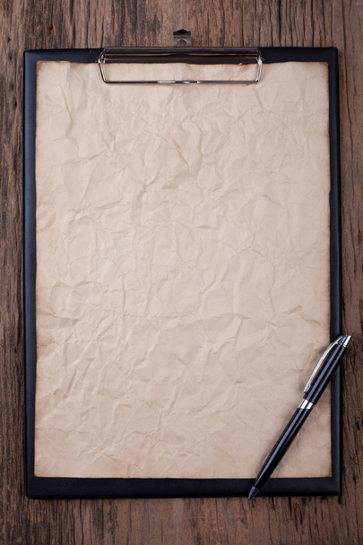 Antiguo papel en blanco en el portapapeles con espacio sobre fondo de madera
 - Foto, Imagen