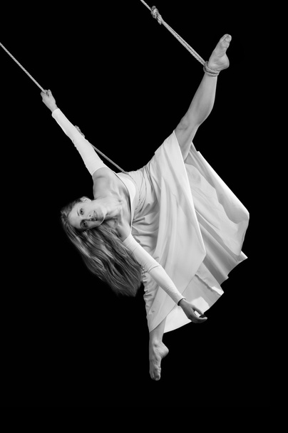 Young woman gymnast in white dress on rope - Foto, afbeelding