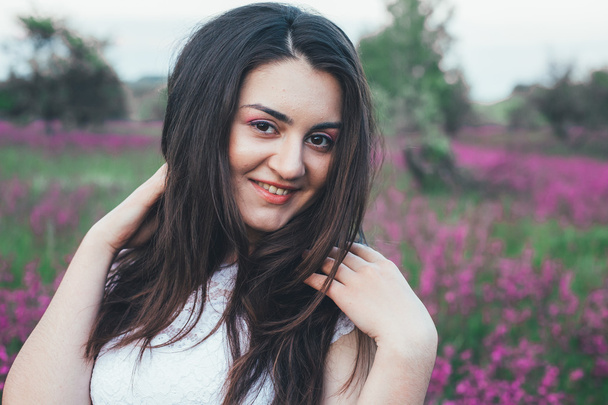 Красива молода наречена в полі, щаслива жінка насолоджується квітами
. - Фото, зображення