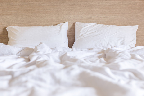 Lençóis brancos e travesseiro, conceito de cama bagunçada
 - Foto, Imagem