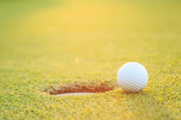 Golf ball on lip of cup  in course - Foto, Imagem