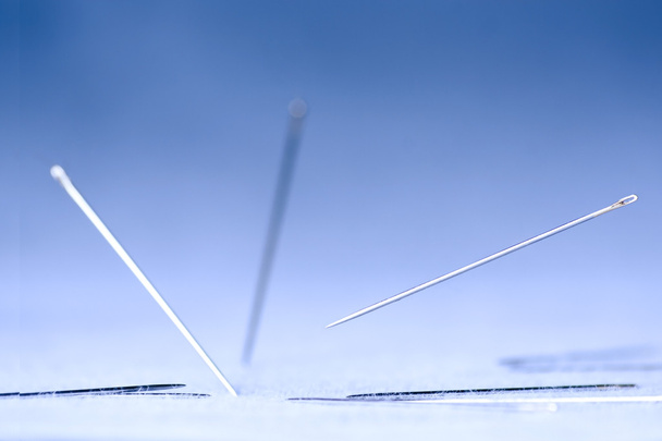 Extrema close-up de agulhas caindo em tecido
 - Foto, Imagem