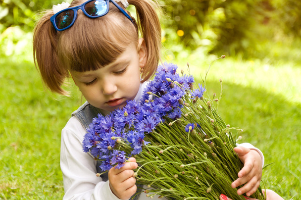 маленькая девочка с букетом цветов - Фото, изображение