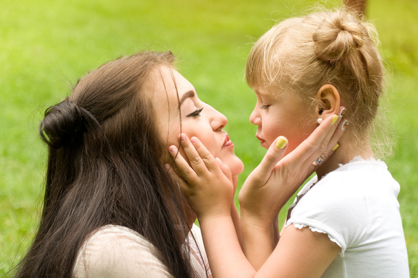family spends time in nature. daughter gently kisses mother - 写真・画像