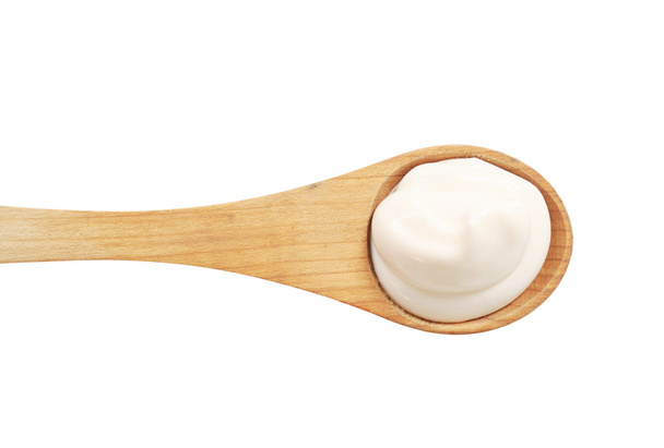 Crema blanca sobre una cuchara de madera
 - Foto, imagen