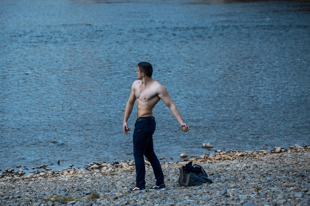 muscular man with bag near water - Foto, immagini