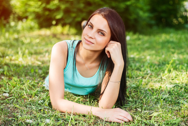 Krásná žena, relaxační venku na trávě a při pohledu. - Fotografie, Obrázek