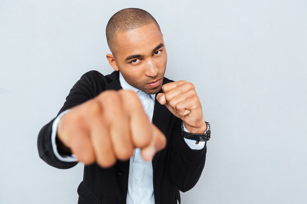 Angry young businessman standing in boxer position ready to fight - Foto, immagini