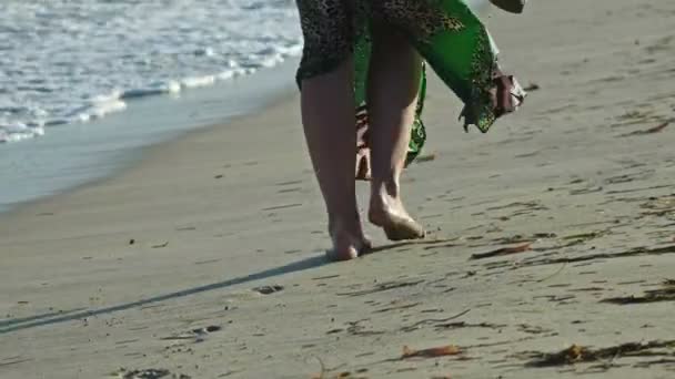 Jonge vrouw In lange jurk wandelen langs de zee, beweegt weg, close-up de voeten, slow-motion - Video