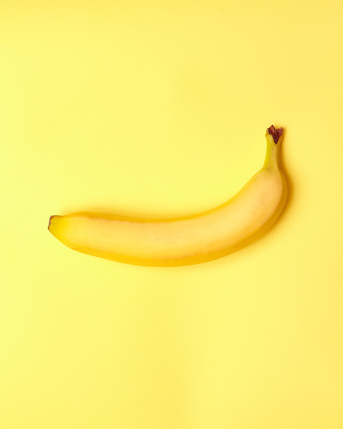 Isolated banana with measuring tape on a yellow background - Zdjęcie, obraz