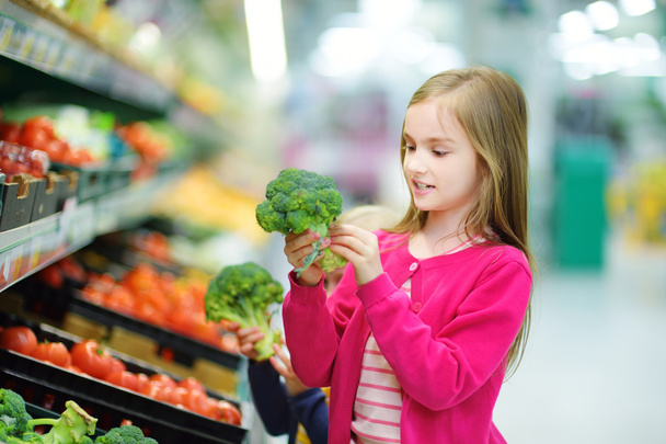 Little girl choosing broccoli - Foto, imagen