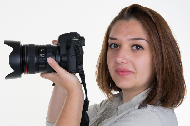 Donna scatta immagini in possesso di fotocamera fotografica, isolato su un bianco - Foto, immagini