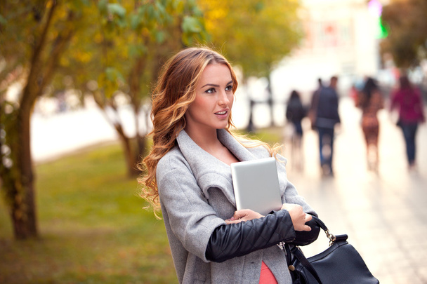 Walking in a park. A businesswoman with a tablet walking in a city park. - Fotografie, Obrázek