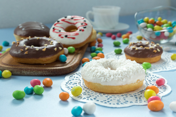 Donuts savoureux avec fruits et bonbons sur la table
 - Photo, image