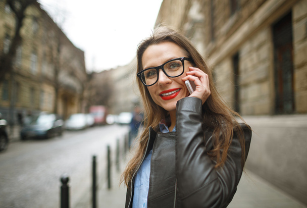 Businesswoman walking down the street while talking on smart pho - Fotografie, Obrázek