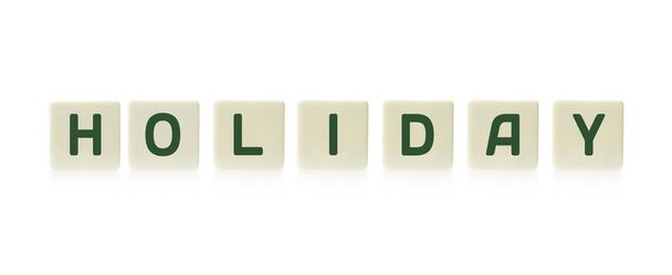 Woord "Holiday" aan boord van spel vierkant plastic tegel stukken, geïsoleerd op een witte achtergrond. - Foto, afbeelding