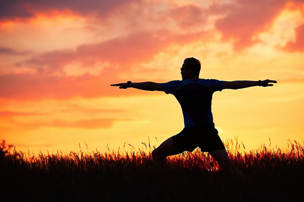 Людина практикує йогу під час заходу сонця
 - Фото, зображення