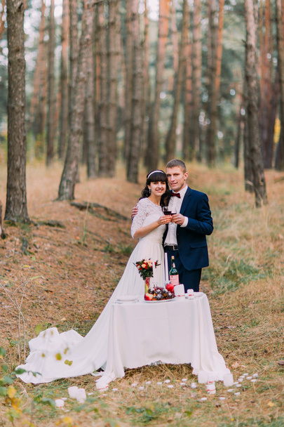 Romantic autumn pine forest picknick of happy just married couple - Zdjęcie, obraz