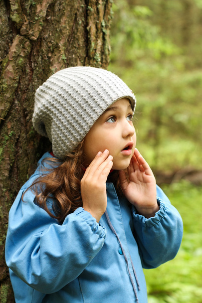 Little girl in a blue cloak, lost in the woods. - Фото, зображення