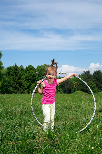 Smiling Little Girl With Hula Hoop Enjoying Beautiful Spring Day In The Park - Fotó, kép