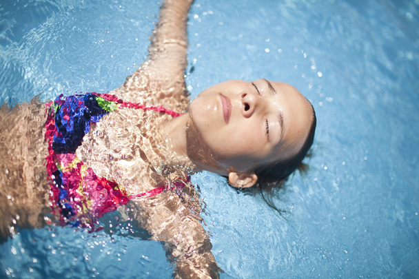 Girl in the swimming pool in the very sunny day - Photo, Image