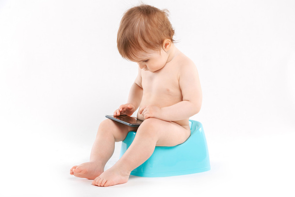 kid with a phone on the potty - Φωτογραφία, εικόνα