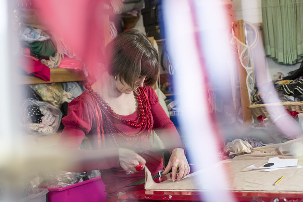 Lady Tailor travaillant sur un tissu sur une table de découpe
 - Photo, image