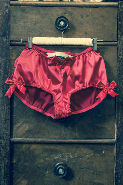 Пара красных трусиков, прикрепленных к одежде
 - Фото, изображение