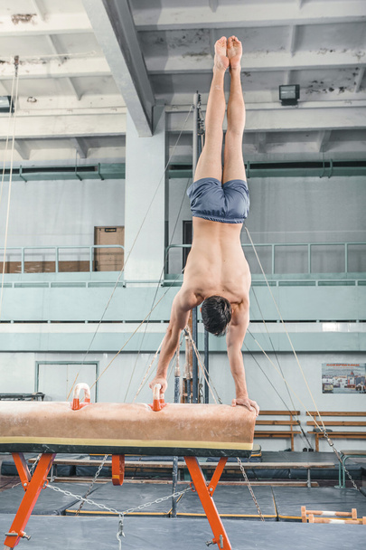 The sportsman during difficult exercise, sports gymnastics - Foto, Bild