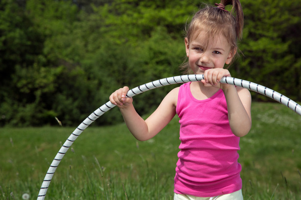 Smiling Little Girl With Hula Hoop Enjoying Beautiful Spring Day In The Park - Valokuva, kuva