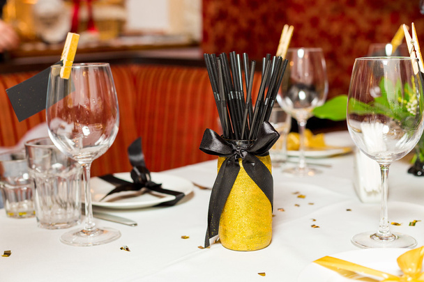 Cadre de table d'invités d'anniversaire avec des fleurs fraîches dans le style noir et or, intérieur
 - Photo, image