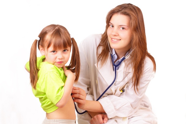 Medical doctor woman inspects beautiful little girl - Foto, imagen