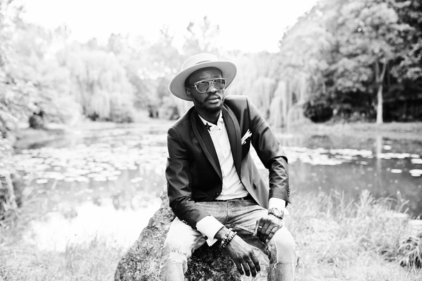 Portrait of stylish rich black man at blue jacket, hat and sungl - Foto, afbeelding