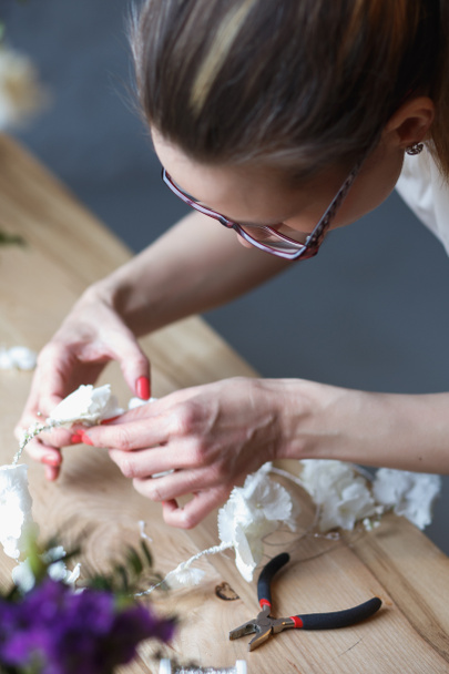 Florist at work: woman making floral composition of different flowers - Фото, зображення