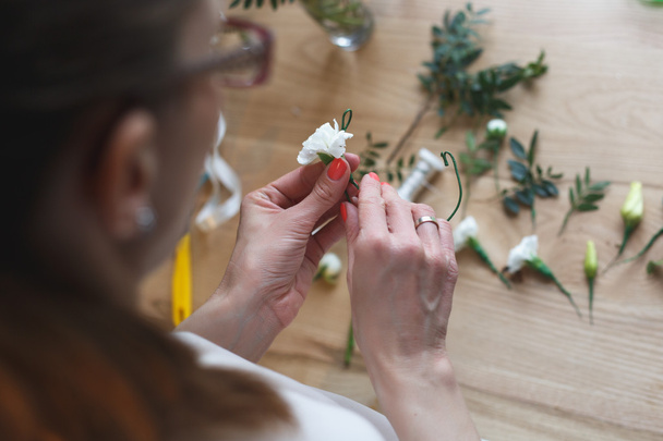 Florist at work: woman making floral composition of different flowers - Photo, image