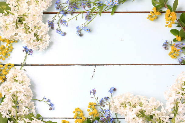 Frame spring flowers blue wooden background flat lay, overhead view - Φωτογραφία, εικόνα