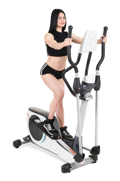 young woman doing exercises on elliptical cross trainer - Foto, afbeelding