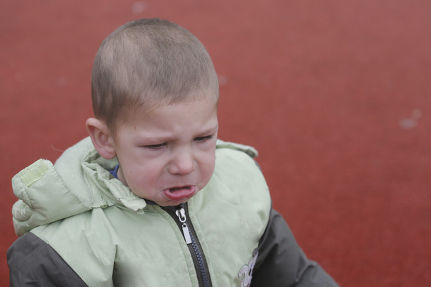 Enfant en bas âge pleurant dehors dans l'aire de jeux
 - Photo, image