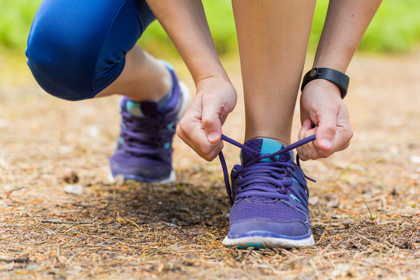 Close up of woman tying shoe laces in summer workout. - Foto, Imagen