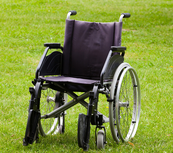 Tyhjä pyörätuoli nurmikentällä
 - Valokuva, kuva