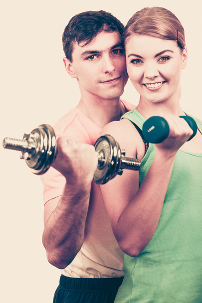 ダンベルの重りを持ち上げる運動のカップル  - 写真・画像