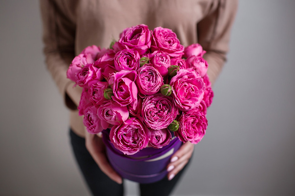 Bogaty bukiet różowy eustoma i róże kwiaty, zielony liść w rękę wiosna świeży bukiet. Lato na tle. hatbox skład - Zdjęcie, obraz