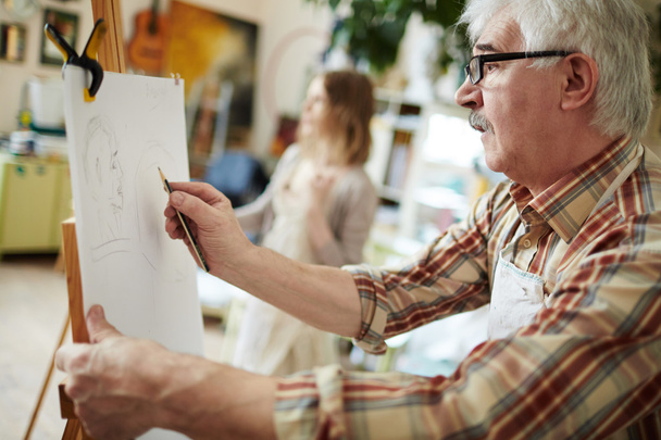 Senior man drawing on easel - Fotografie, Obrázek