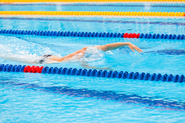 Man swimmer swimming crawl in blue water. - Фото, изображение