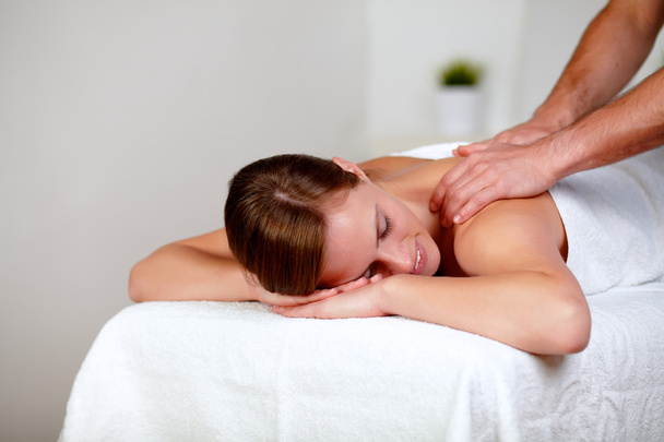 Young woman with eyes closed receiving a massage - Photo, Image