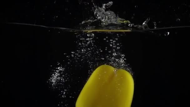 Yellow bell pepper immersing in water, super slow motion video - Кадры, видео