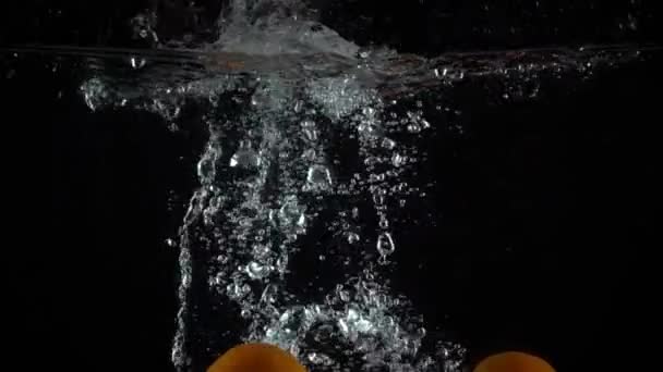 Super slow motion video of several mandarins falling down in water - Metraje, vídeo