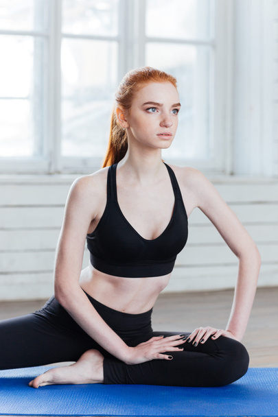 Young fitness woman sitting in yoga position - Foto, afbeelding